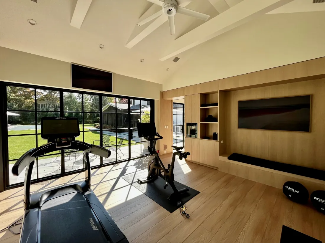 Fitness room with floor-to-ceiling steel windows and oak built-ins