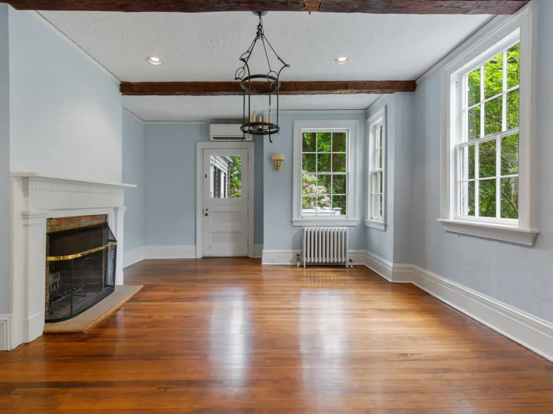 Dining room with exposed beams, a fireplace and light blue walls