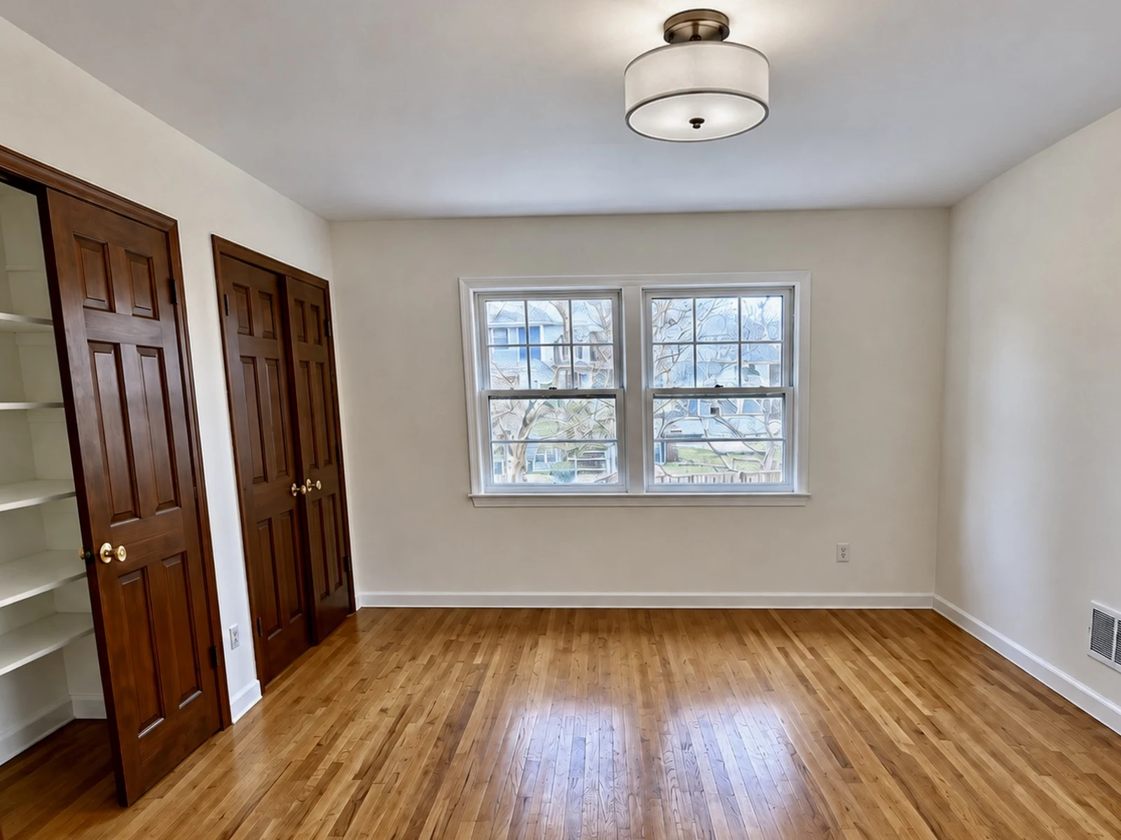 Bedroom after: refinished hardwood floors, fresh paint and a new ceiling fixture