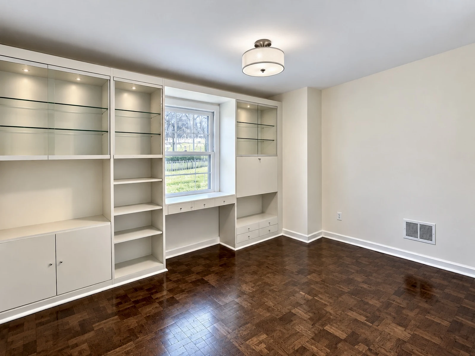 Office after: wallpaper removed, built-ins painted with lit glass shelves, fresh paint and new light